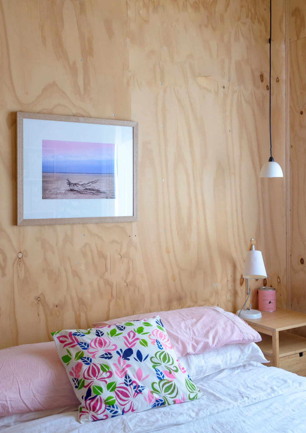 A pink bedroom with wooden walls