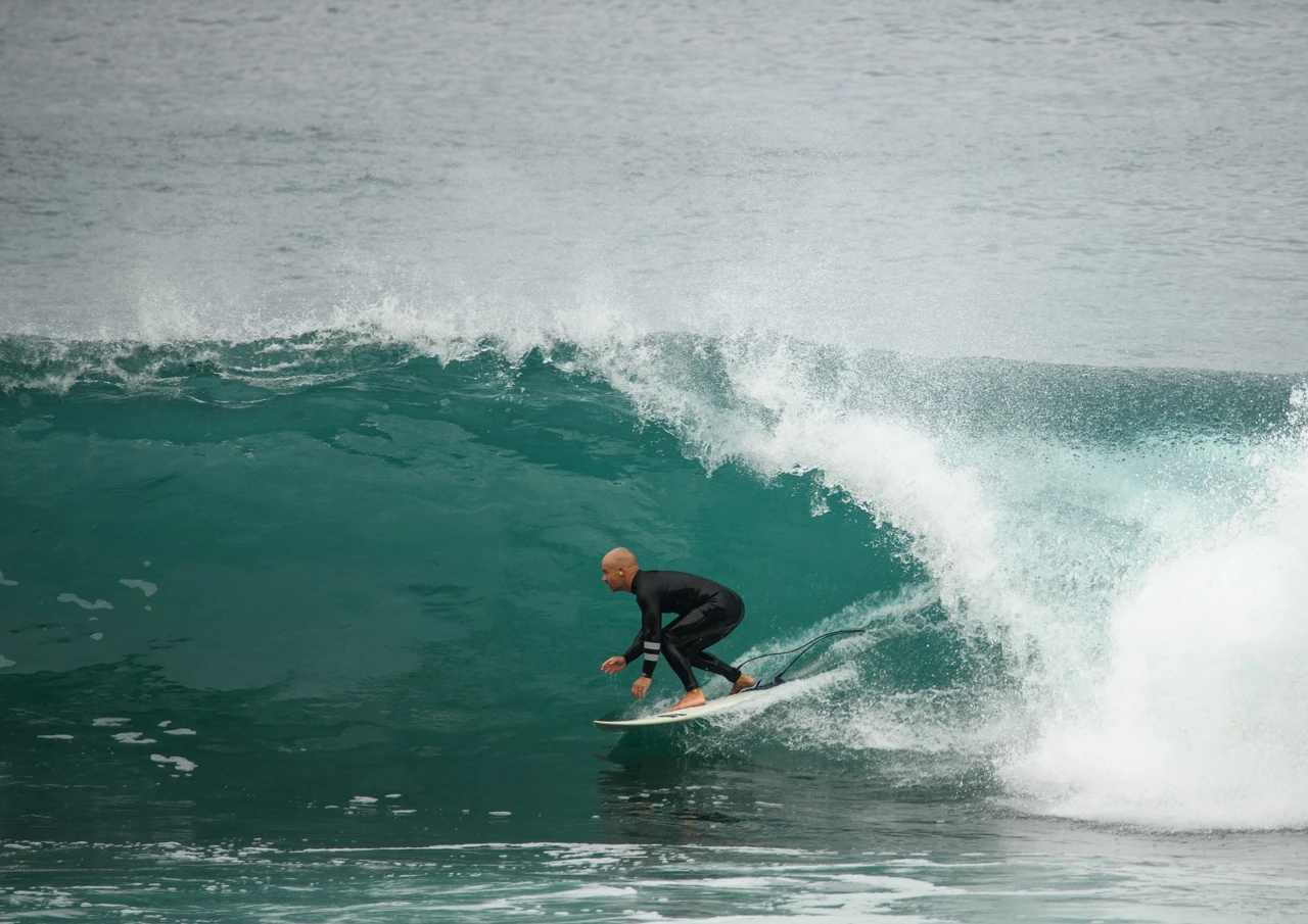 Surfer and green ocean wave