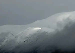 A streak of light over snowy mountains
