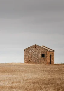 Old stone cottage, abandoned in a wheat field
