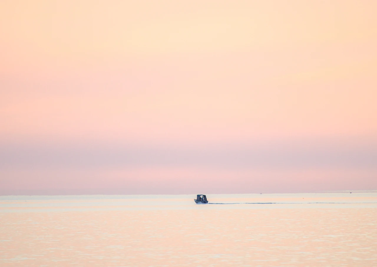 Tiny fishing boat going home Fishing boat staying out till the end of the day.