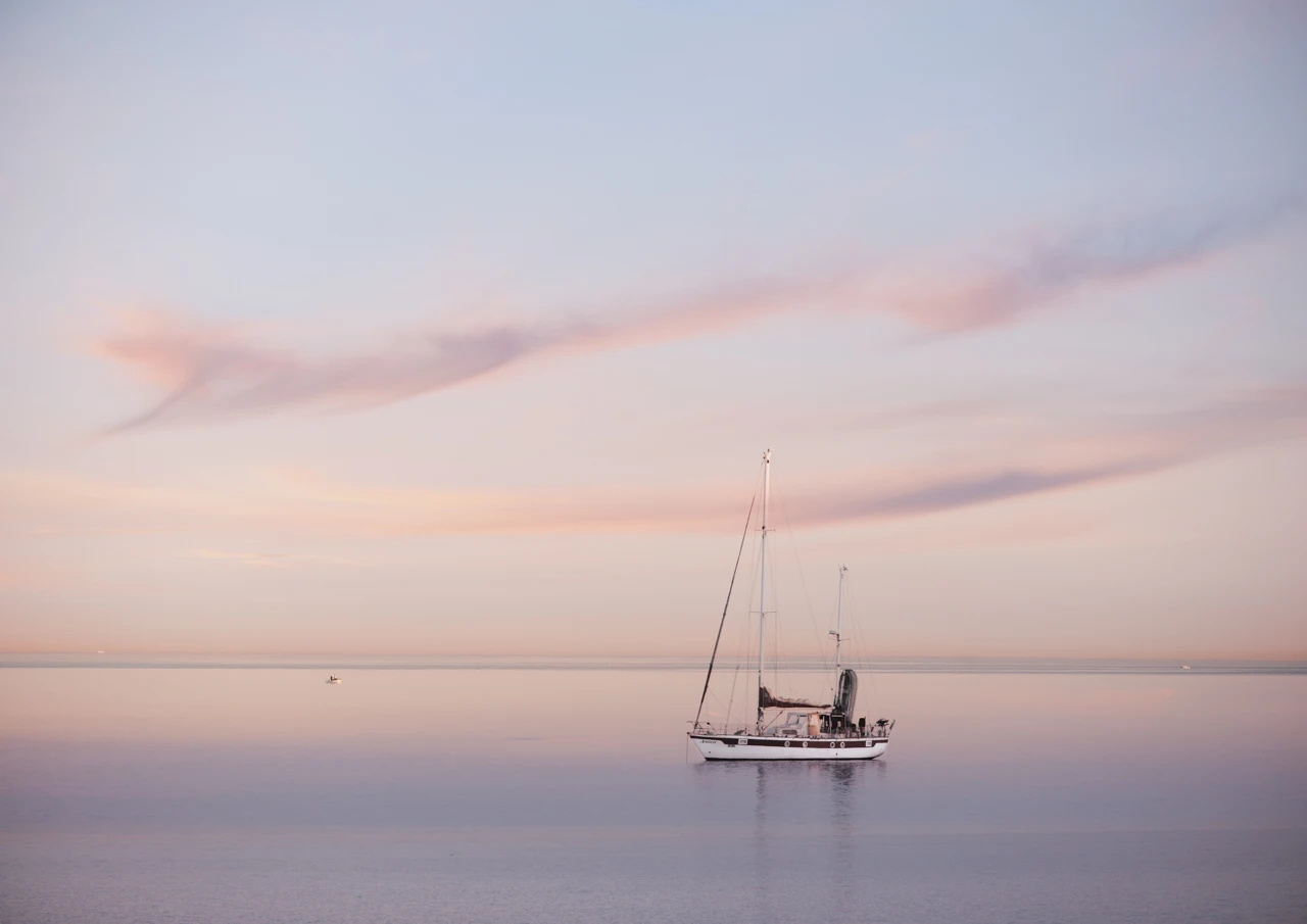 Yacht moored by the beach Yacht moored in pink sunset
