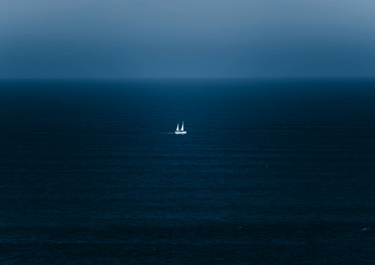 Blue ocean and white sails Blue ocean and tiny white sail