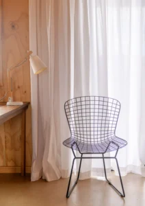 Nice chair by the white curtain