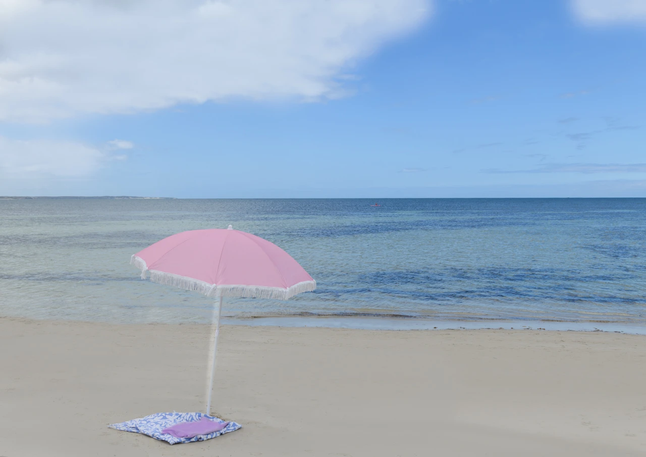 Pink umbrella on a sandy beach