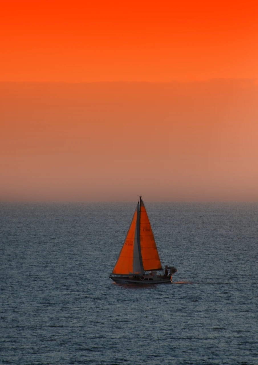 Red sky and a yacht sails by