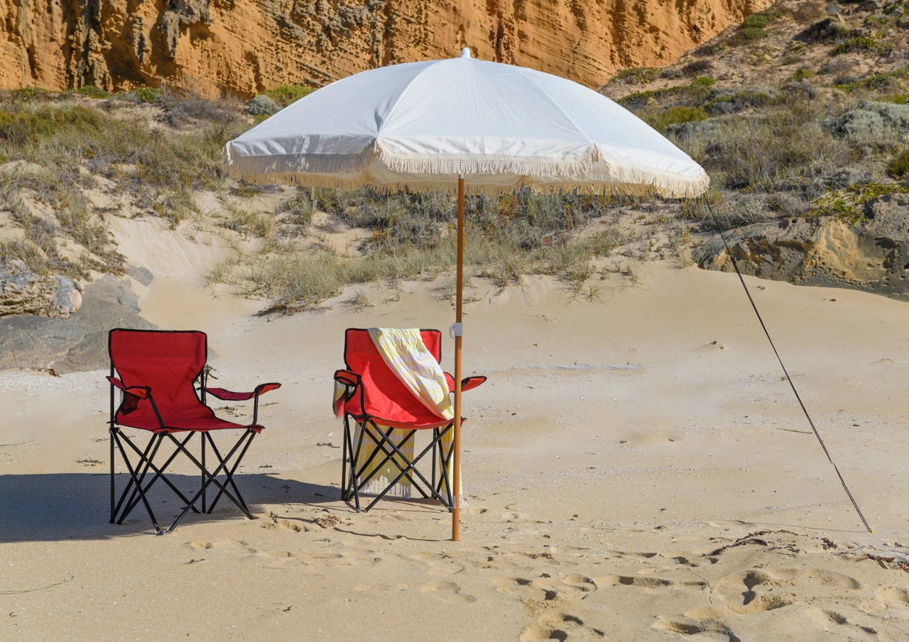 Two red sun chairs at a sandy beach