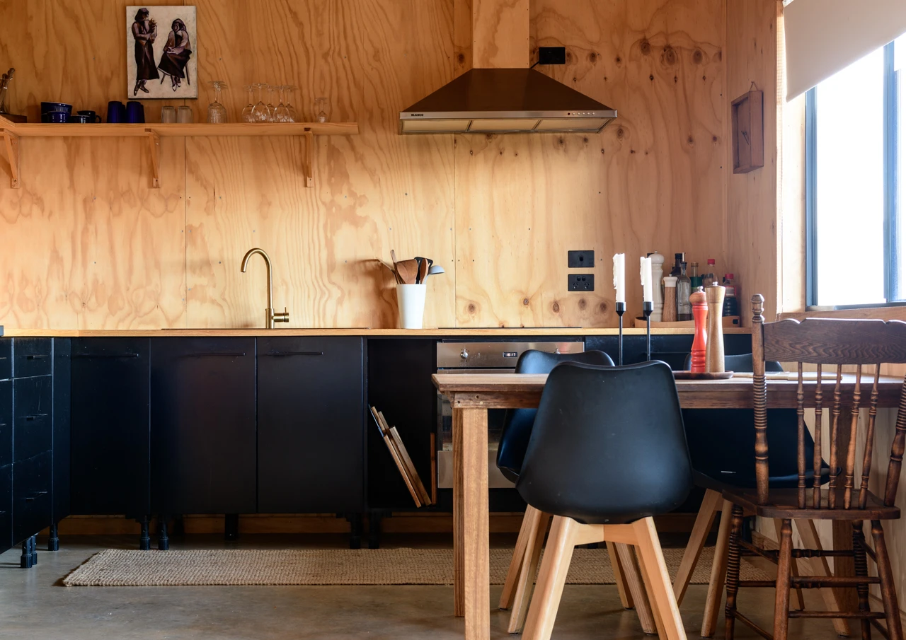 Kitchen black cupboards and wooden walls
