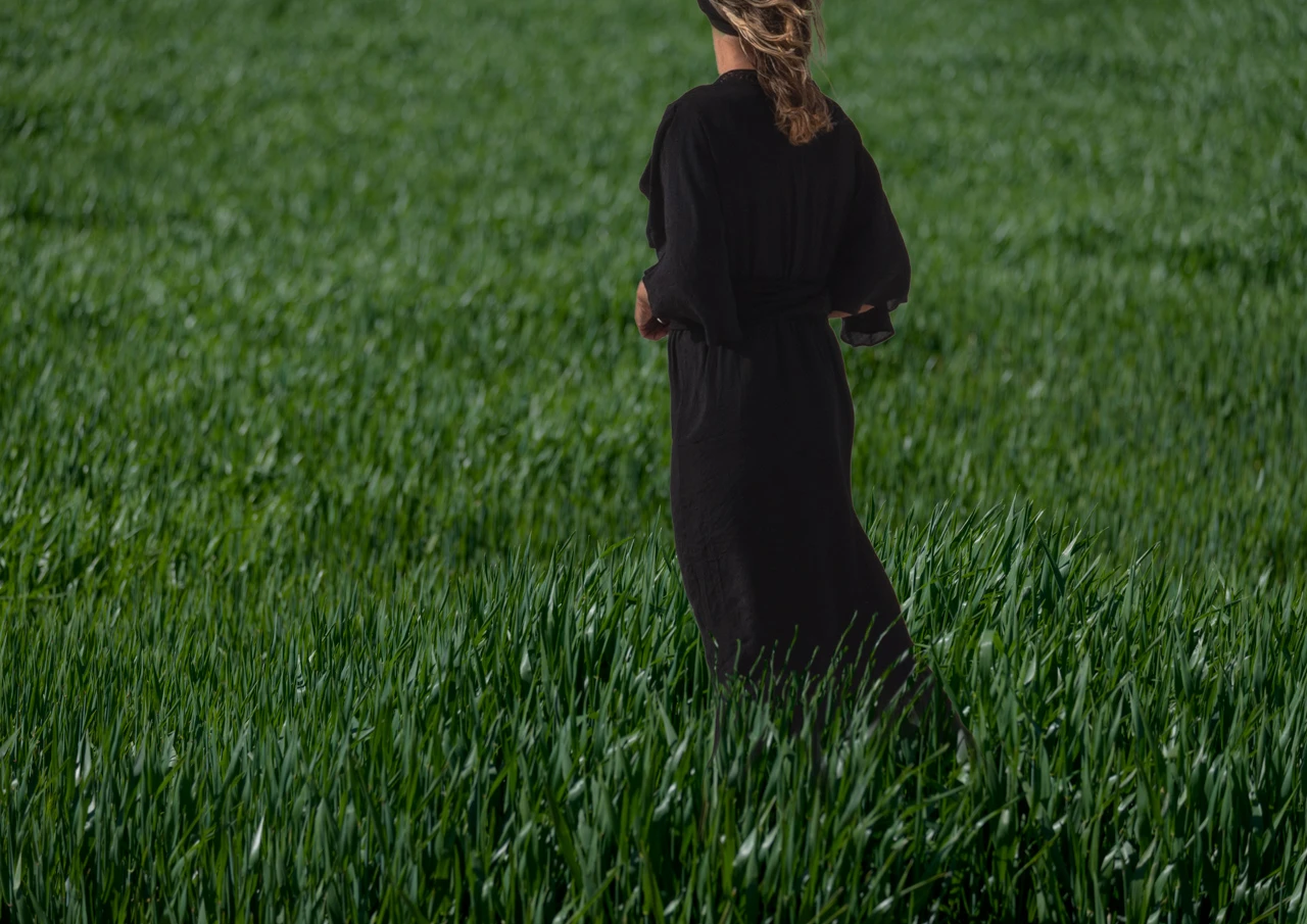 Girl in black dress in green field