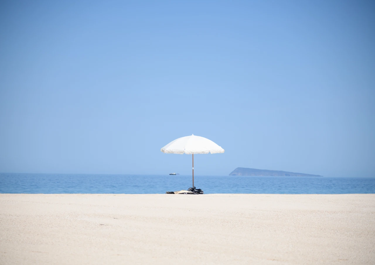 One white umbrella on an isolated beach One white umbrella at West Cape