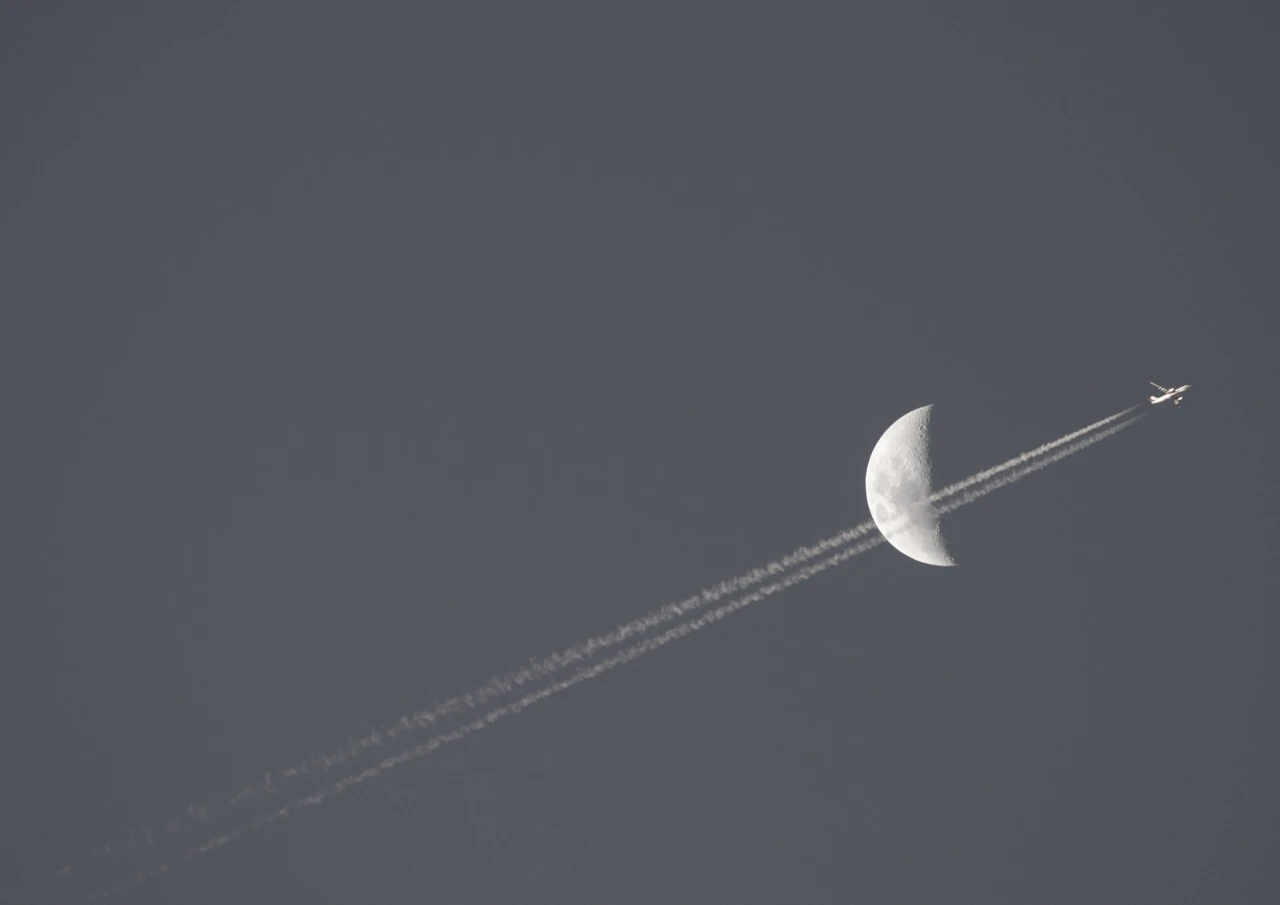 Aeroplane flies past the moon Aeroplane and moon in the sky
