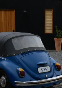 Blue VW car parked outside black house