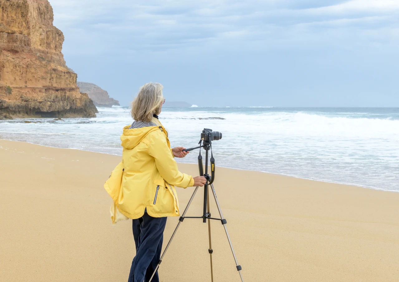 Girl in yellow jacket with camera and tripod Girl in yellow jacket with tripod taking photos