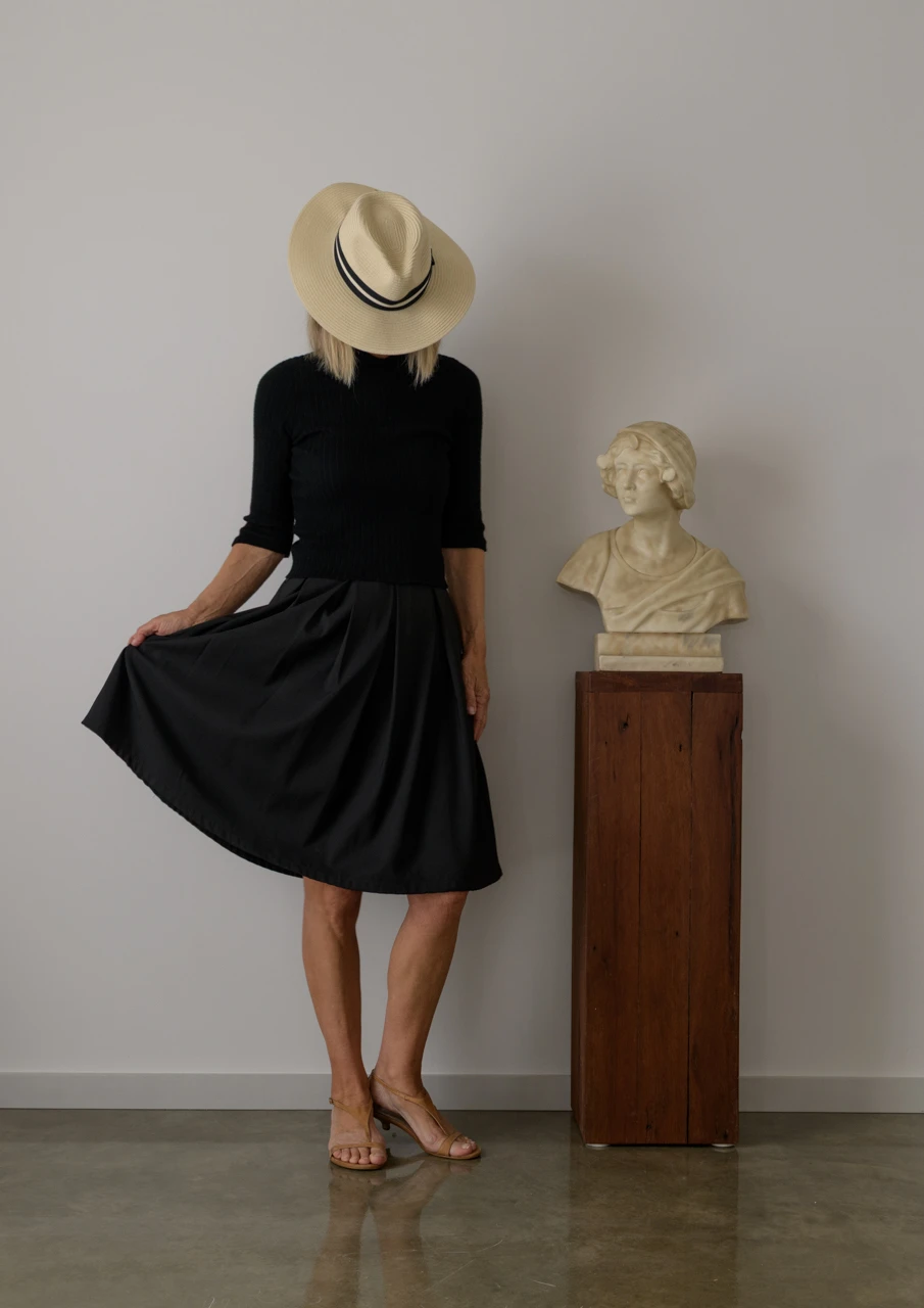 Wendy Philip in black, beside marble bust Wendy Philip in black skirt beside marble bust