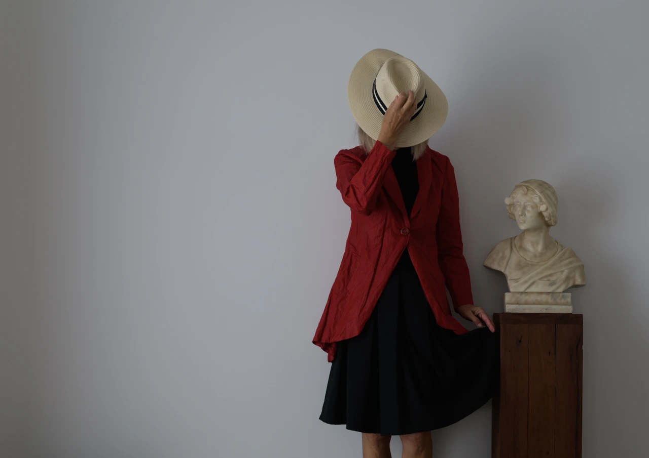 Wendy and statue Wendy Philip in red coat and marble bust stands beside