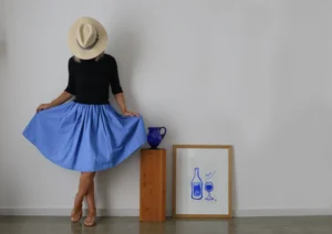 Woman in a blue skirt with hall stand and painting
