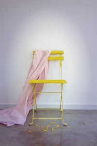 Yellow summer chair and pink material draped over it