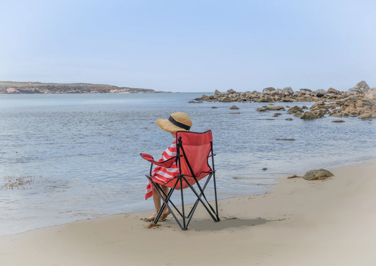 Red chair and girl sitting with red towel Red chair and girl at the beach vintage style
