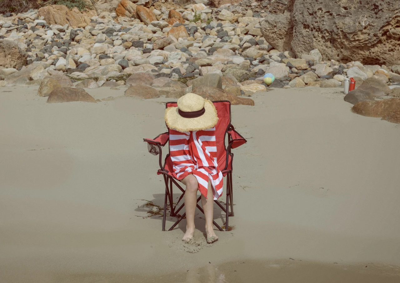 Young girl at the beach with red striped towel