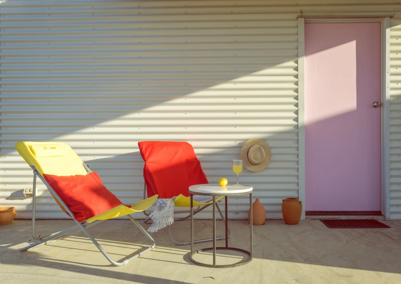 Outdoors at the beach house pink door and yellow sun chairs