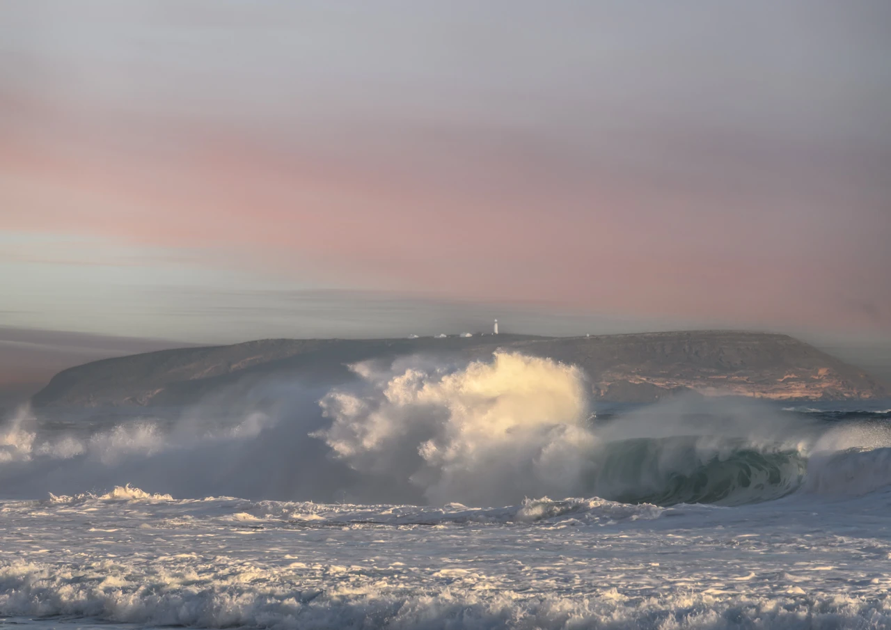 Pink sky at night and huge waves with Althorpe Island lighthouse Pink sky and a big swell at west cape beach Yorke Peninsula
