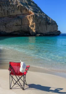 hat and red chair at the beach
