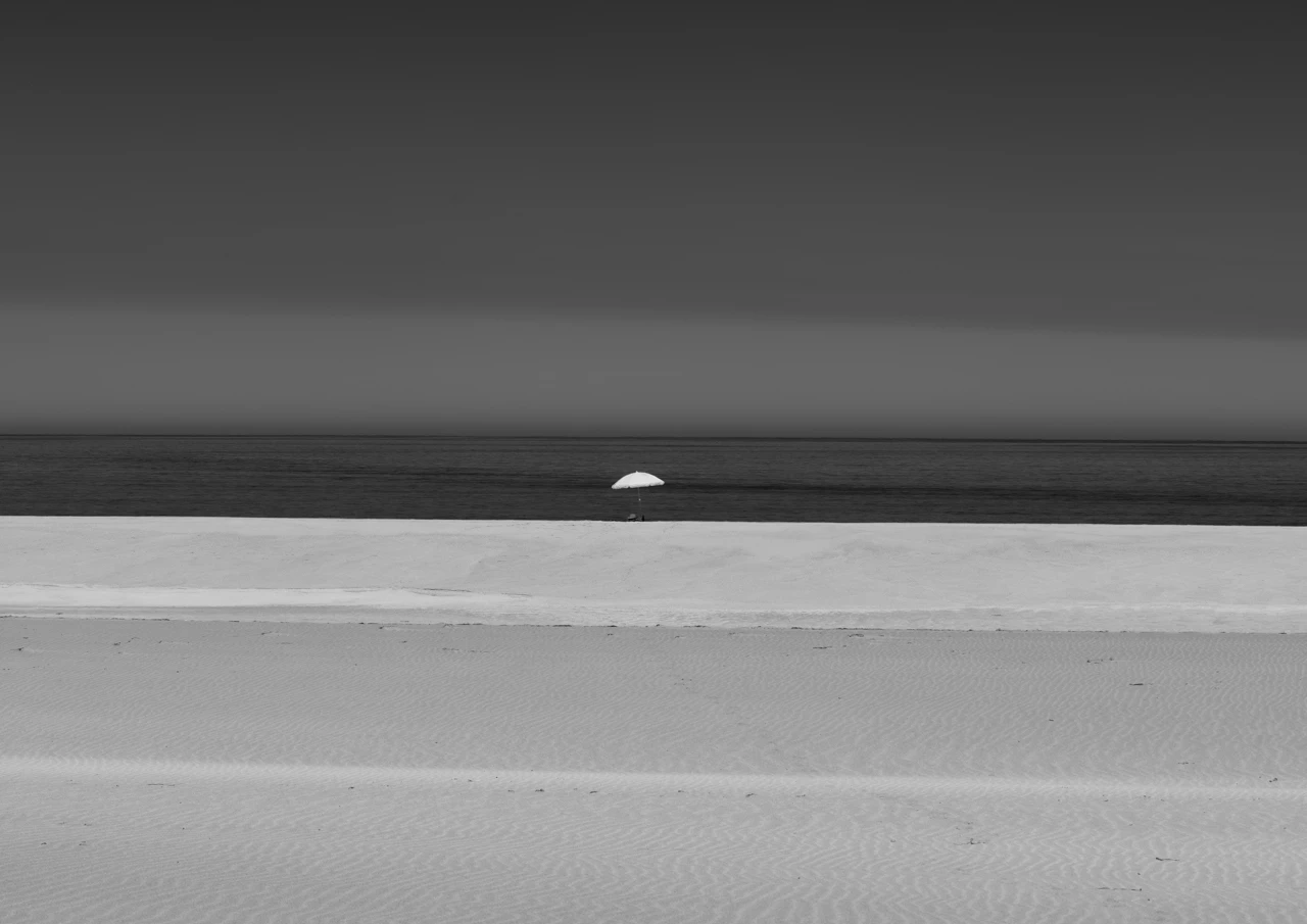West cape on a calm day and one white umbrella