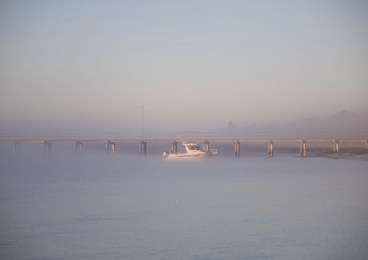 Fishing boat leaving in the morning fog